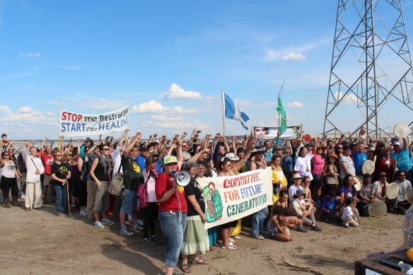 Participants in a June 2014 "healing walk" around oilsands facilities stop near a pond filled with toxic tailings waste.